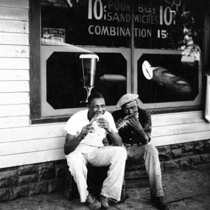 Old photo of two guests eating sandwiches